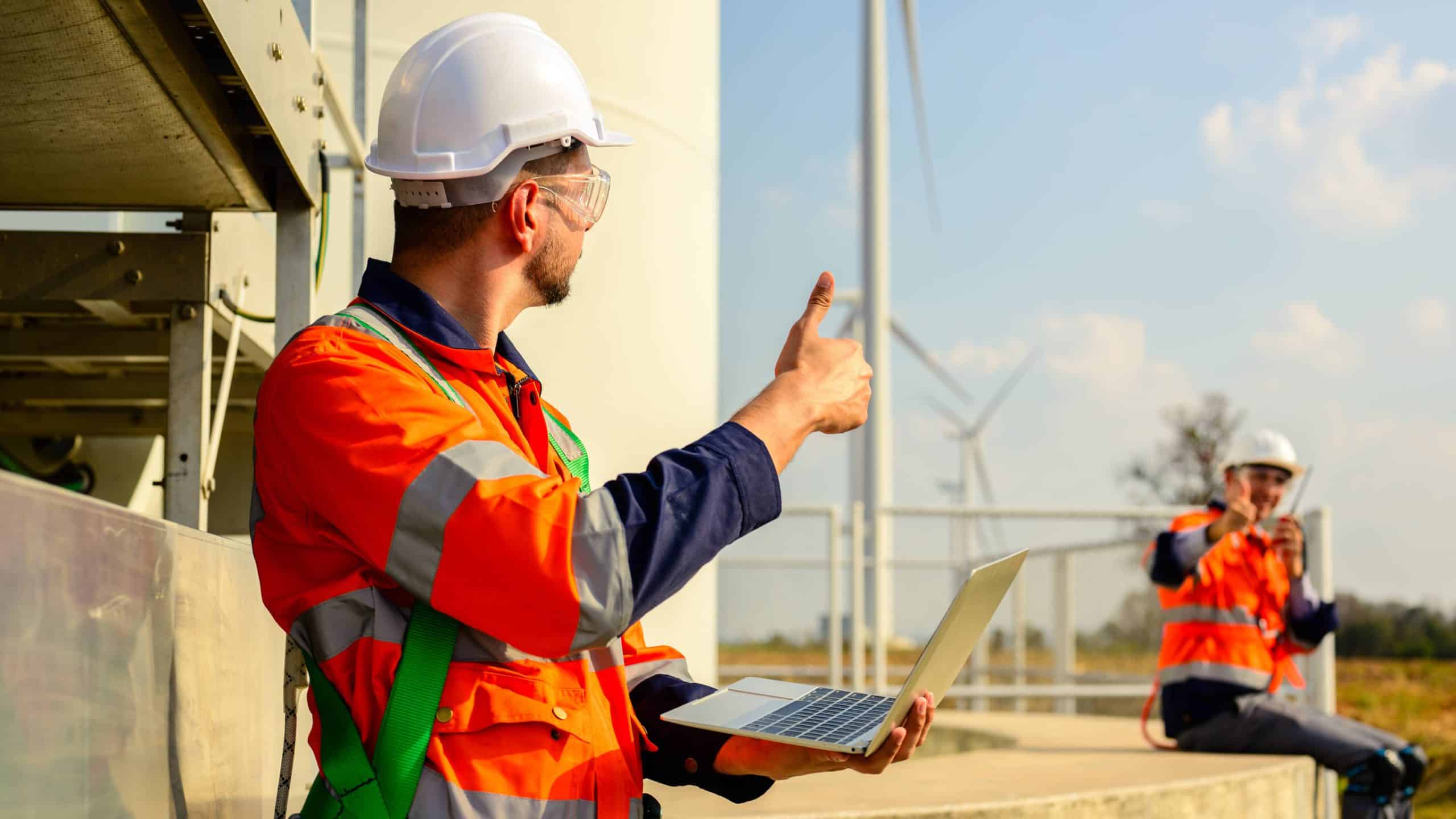 Professional engineers technicians working at wind turbine farm field