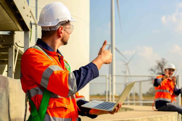 Professional engineers technicians working at wind turbine farm field